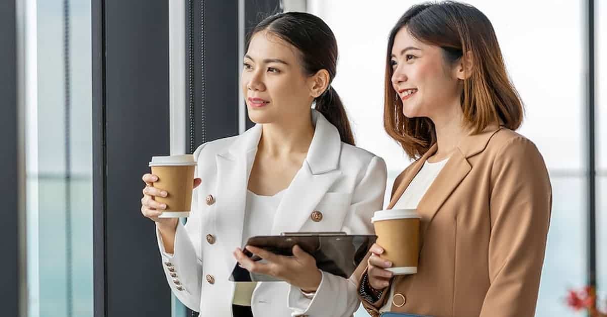 Two female entrepreneurs sipping coffee