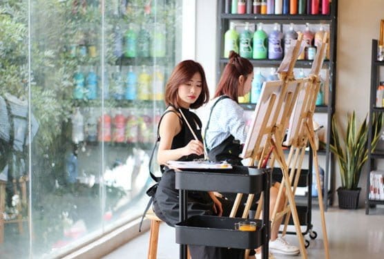 Two ladies during a painting class session at Art & Bonding