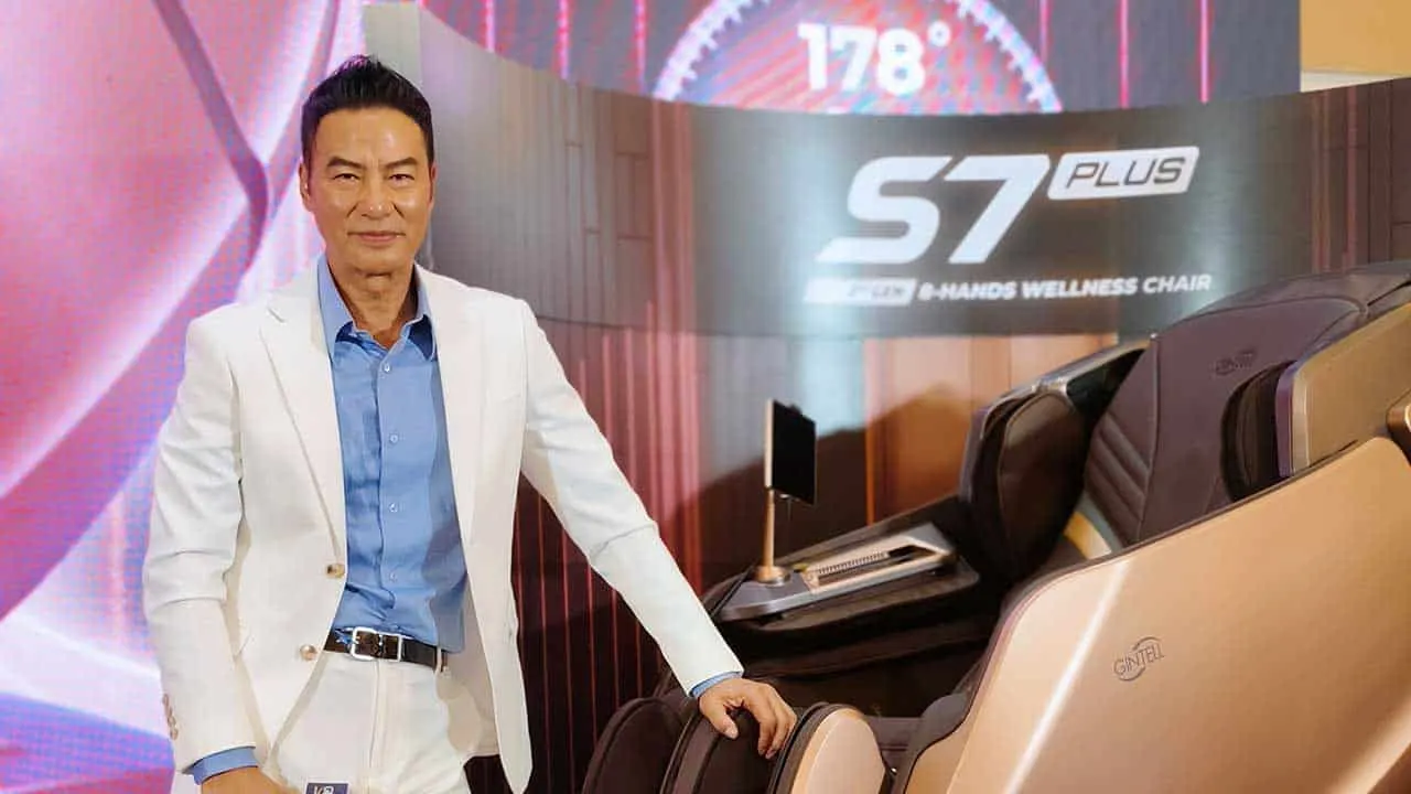 Simon Yam, posing confidently next to the GINTELL S7 Plus Wellness Chair, at the unveiling event.